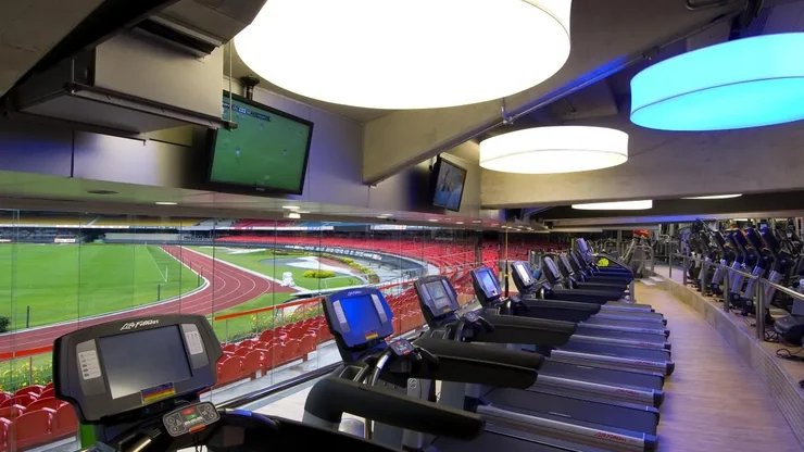 Área de esteiras da CIA Athletica, com vista para a pista de atletismo